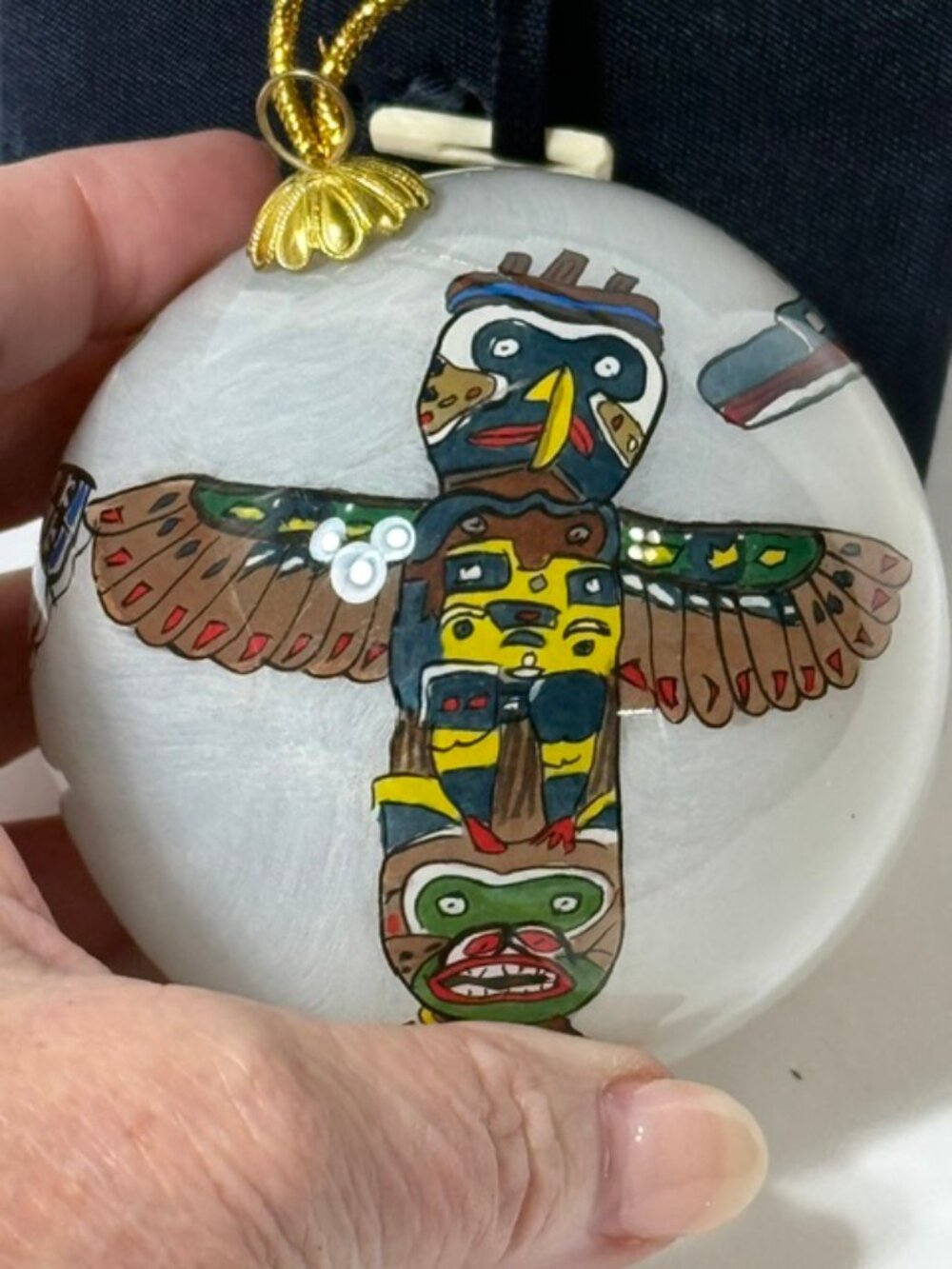 Hand-painted reverse art totem pole glass ornament.